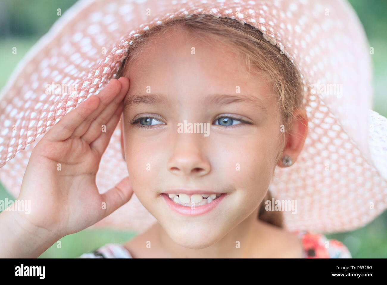 Estate ritratto di una bella ragazza in un cappello rosa. Il concetto di infanzia e vacanze. Foto Stock