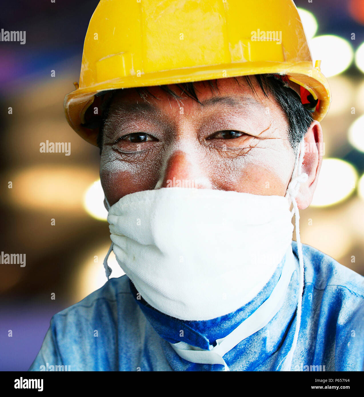 Costruzione cinese lavoratore con una maschera antipolvere. Foto Stock