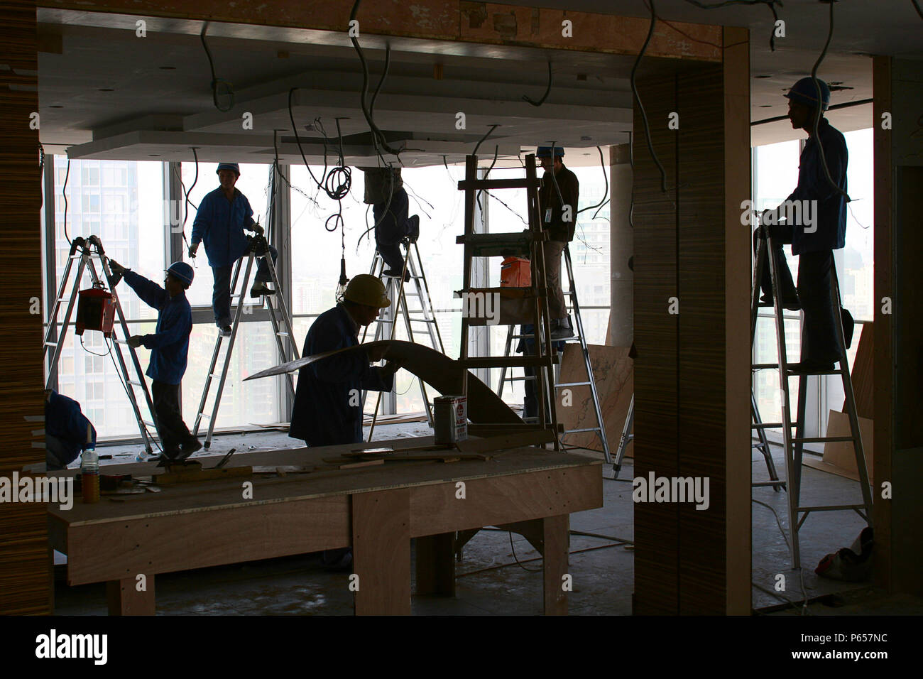 Lavoratori cinesi preparare pareti divisorie in una nuova torre di uffici a Pechino. Foto Stock