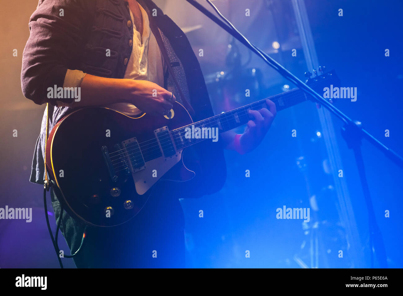 Il chitarrista sul palco gioca su una chitarra elettrica, una foto con morbida messa a fuoco selettiva Foto Stock