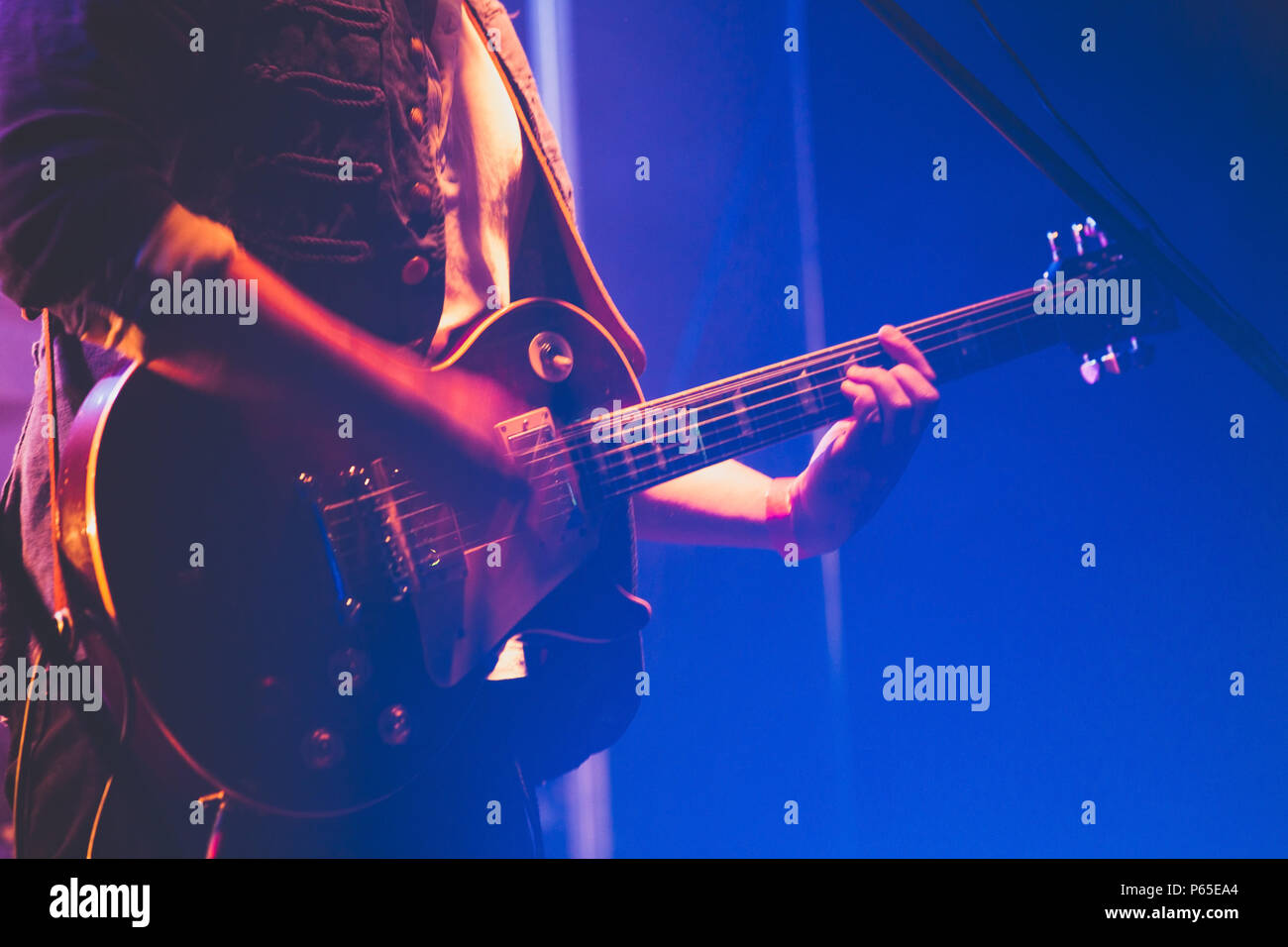 Il chitarrista sul palco gioca solo su una chitarra elettrica, una foto con morbida messa a fuoco selettiva Foto Stock