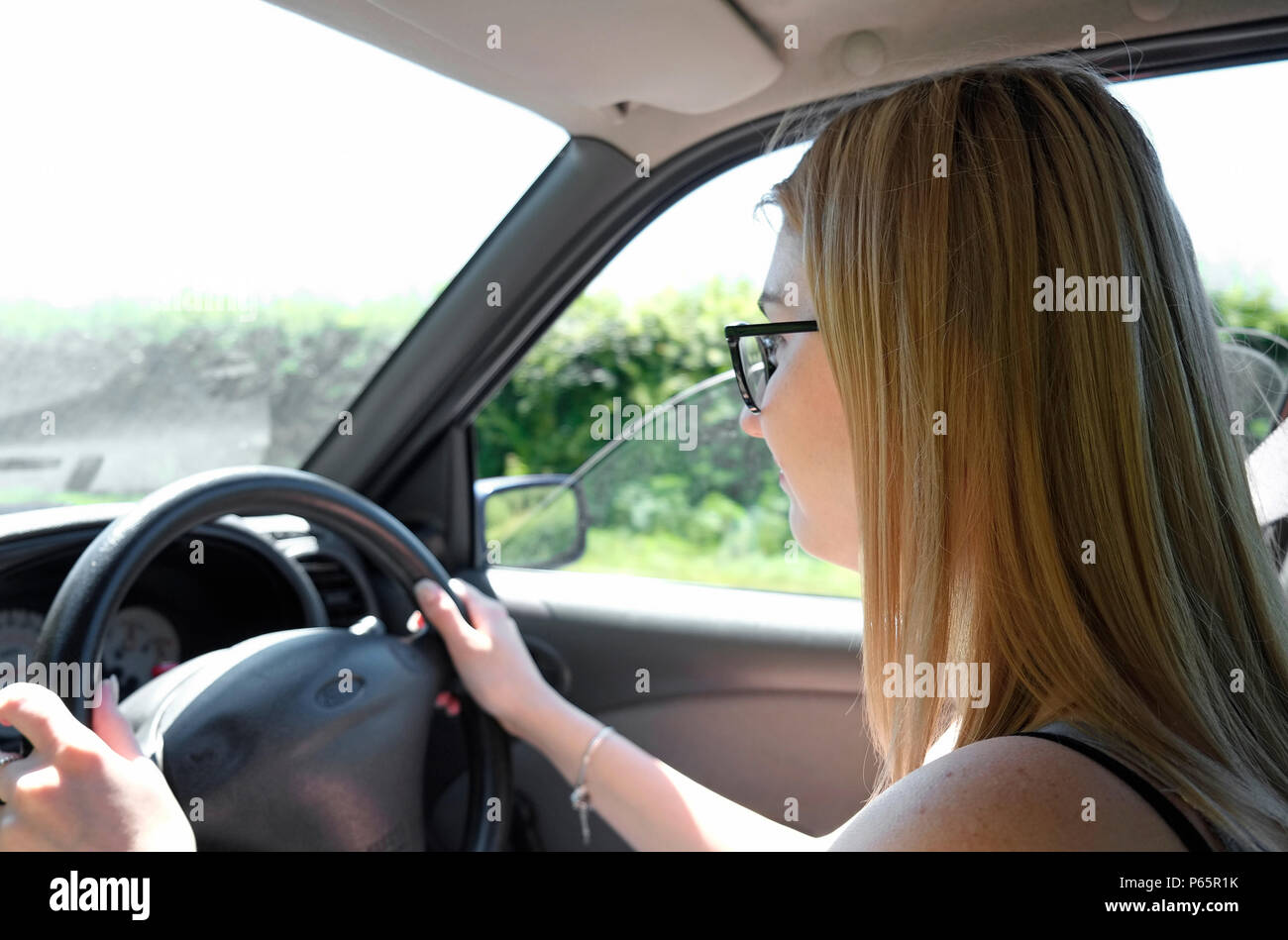 Femmina driver teenage, alla guida di autoveicolo, Norfolk, Inghilterra Foto Stock