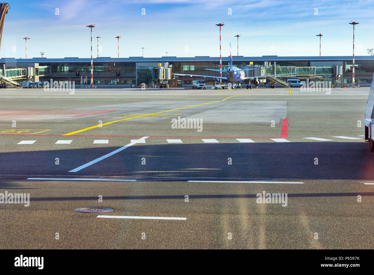 Aereo passeggeri al terminale fisso gates sulla pista di aeroporto, MARUPE, Riga, Lettonia. Infrastrutture per il trasporto su strada di international airport. Aircr Foto Stock