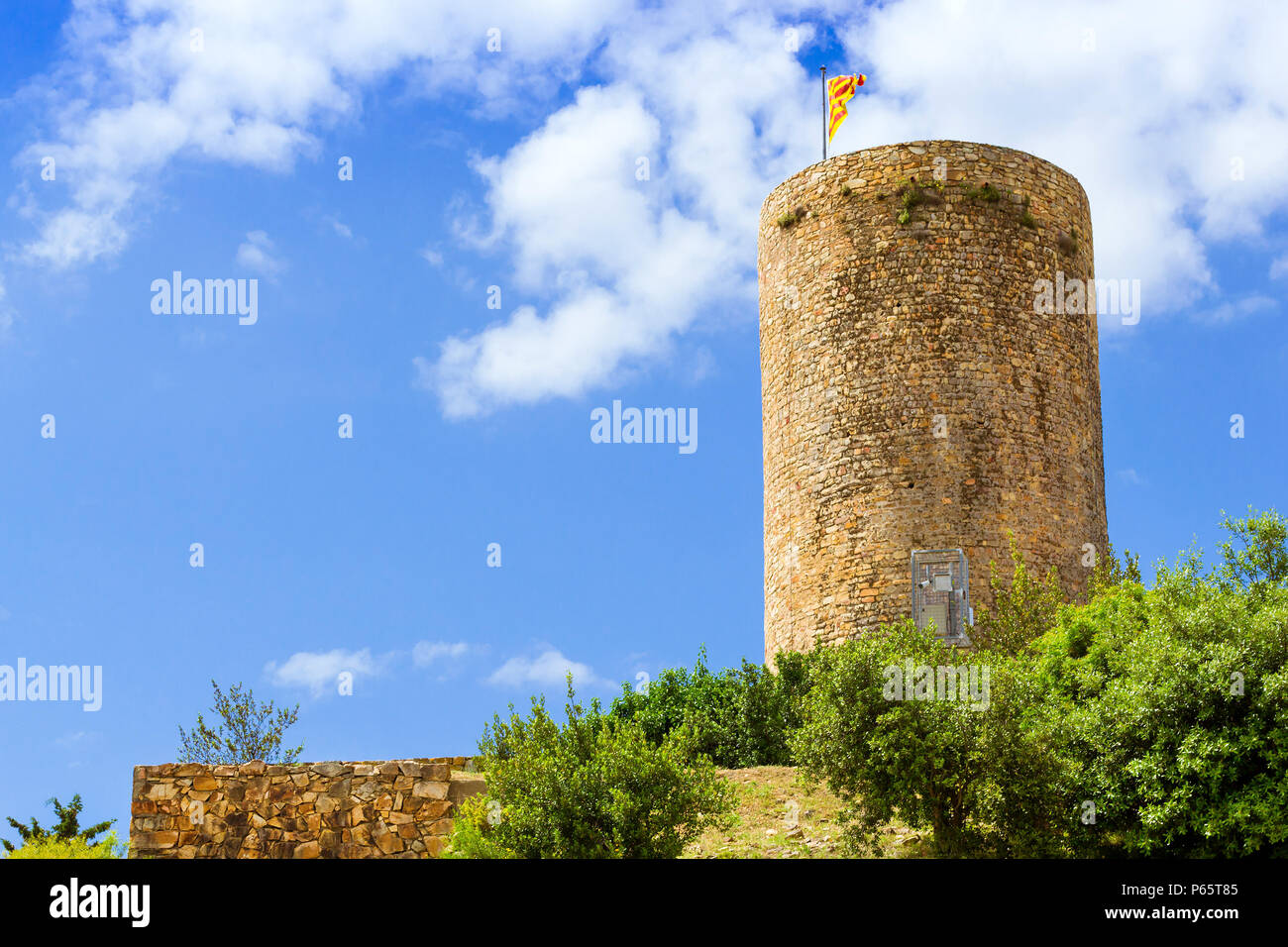 Spanish flag svolazzanti sul pennone sulla torre del castello di montagna San Juan. Costa Brava Catalogna. Sunny View di spagnolo beach resort Blanes in Foto Stock