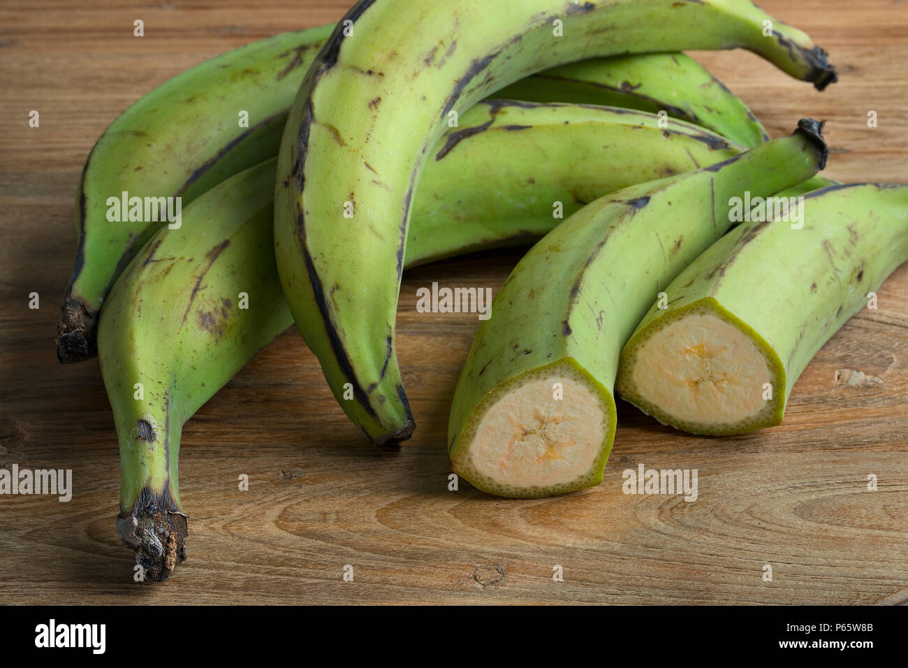 Intero e metà fresco verde banane acerbe Foto Stock