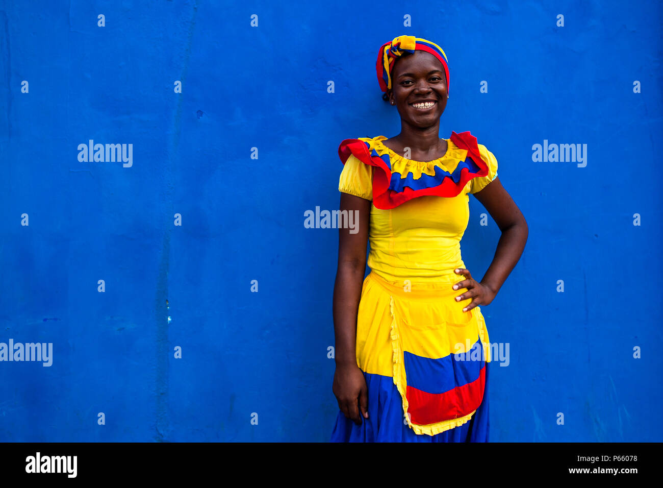 Una ragazza Afro-Colombian, vestito con il tradizionale 'palenquera' costume, posa per una foto nella città murata di Cartagena, Colombia. Foto Stock