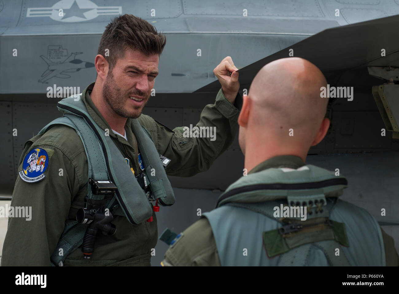 Stati Uniti Air Force Capt. Michael Watts, F-16 Fighting Falcon pilota, spiega l'aeromobile a Jesse Palmer, corrispondente per ABC Good Morning America, prima del loro Volo a Langley Air Force Base, Va., 3 maggio 2016. La F-16 è un multirole jet da combattimento che è compatto e altamente manovrabili, con uno ad alte prestazioni sistema di armi. (U.S. Air Force foto di Senior Airman Kayla Newman) Foto Stock