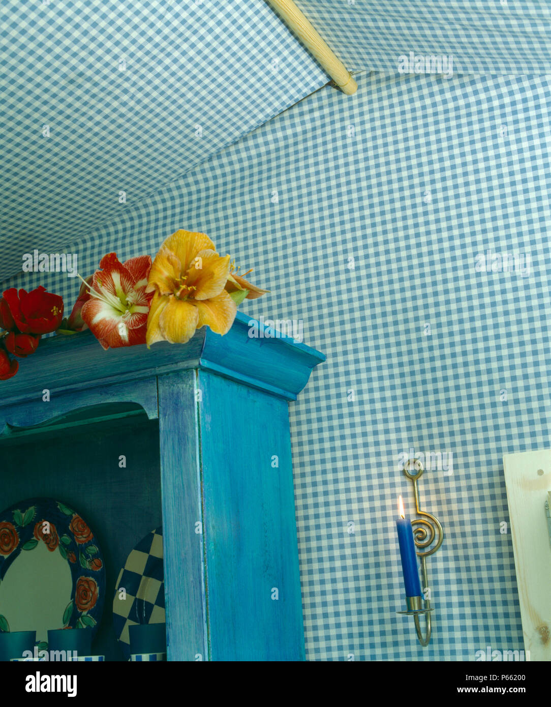 Dipinto di blu armadio contro blu check-in tessuto che ricopre le pareti della Tettoia da giardino Foto Stock