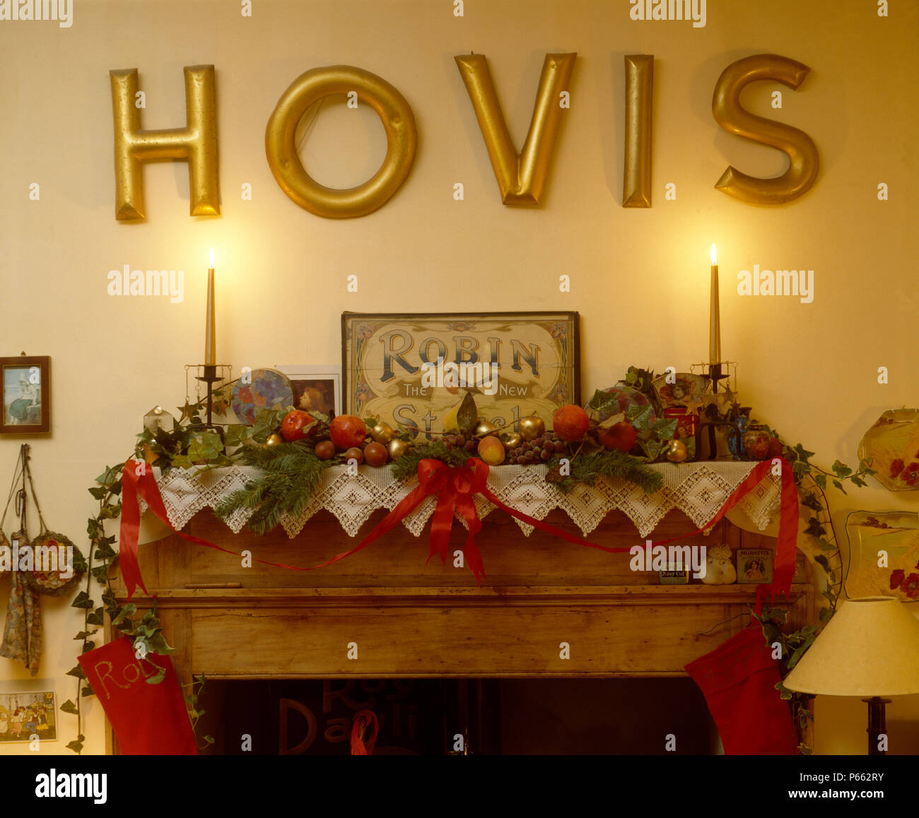 Scrofetta Hovis ha segno sopra mantelpiece decorato per il Natale di edera e di conifere garland sul panno di pizzo Foto Stock