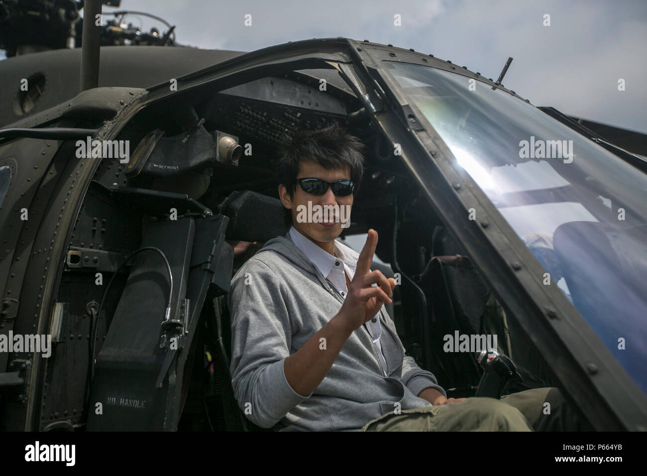 Un locale giapponese pone all'interno di un UH60 Blackhawk durante la Fuji amicizia Festival il 7 Maggio a bordo di bracci combinato Training Center Fuji, Gotemba, Fuji. Il festival comprende giochi e divertimento per tutte le età, come case di bounce, face painting e musica dal vivo da artisti locali e gli Stati Uniti 7 Banda della flotta's Orient Express. Il festival ha avuto anche numerose Visualizza sistemi di armi lungo con aeromobili e veicoli. Tra di loro vi erano i serbatoi di giapponese, UH60 Black Hawk e la MV-22B Osprey. Foto Stock