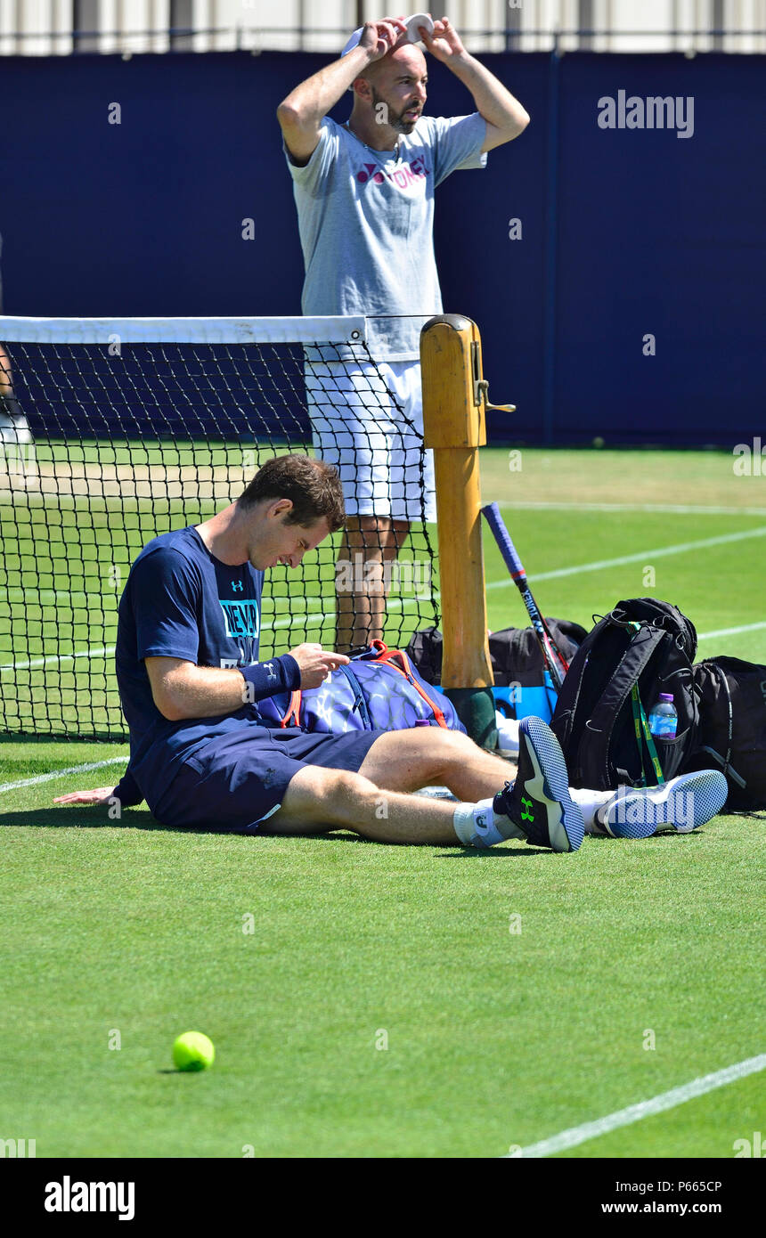 Andy Murray (GB) sul suo telefono cellulare sulla pratica corti con pulmann Jamie Delgado alla valle di natura internazionale, Eastbourne 25 Giugno 2018. Foto Stock