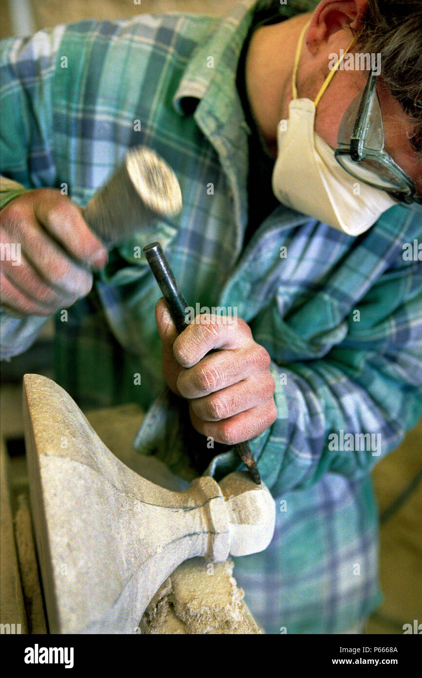 Scalpellino lavorando sulla pietra di ornamento con un martello e uno scalpello Foto Stock