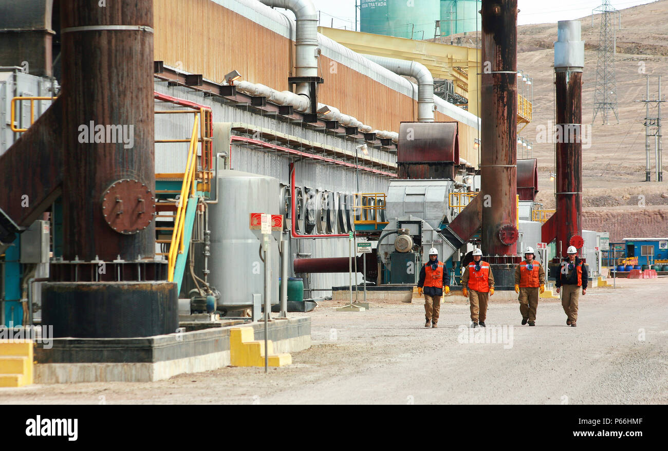 Quattro lavoratori a piedi al di fuori di elettro-impianto vincente, Escondida Cile Foto Stock