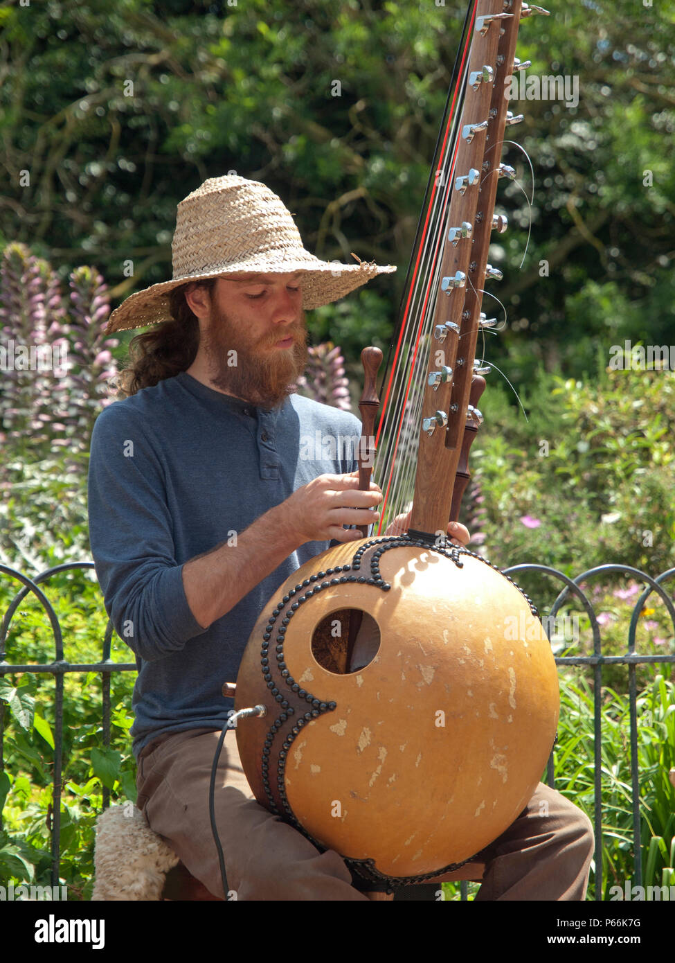 Musicista di strada in Pavilion Gardens Brighton un uomo gioca un arpa africana Foto Stock
