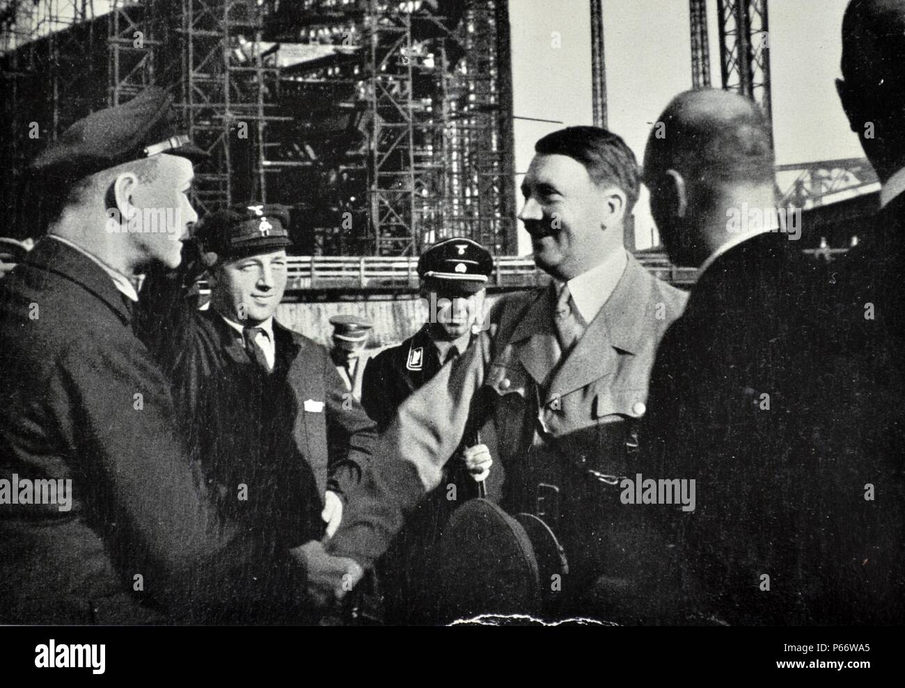 Adolf Hitler visita il Blohm & Voss la cantieristica e opere di ingegneria. La società ha costruito aerei attraverso la Hamburger Flugzeugbau prima e durante la Seconda Guerra Mondiale. In Germania il riarmo in violazione del Trattato di Versailles ha comportato un grande cambiamento in fortune per la società, eseguire quindi dai fratelli Rudolf e Walther Blohm, che era uscito da una profonda crisi. Dal luglio 1944 all'aprile 1945 la società ha utilizzato i detenuti della propria concentrazione sub accampamento presso il suo cantiere in Hamburg-Steinwerder, una sub-camp di Neuengamme campo di concentramento. Foto Stock