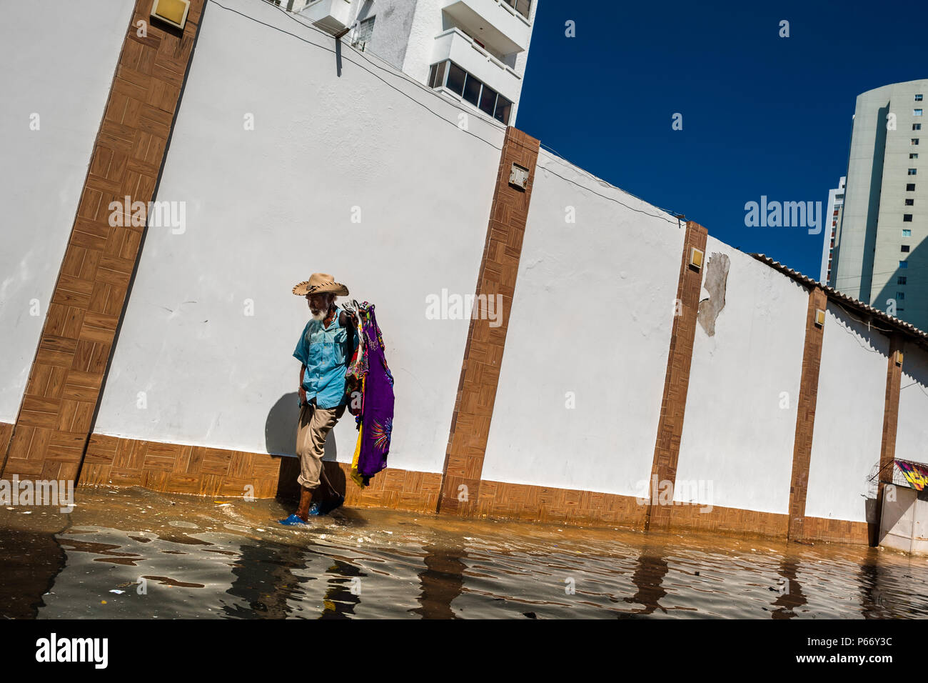 Un colombiano venditore ambulante, portando gli accessori di moda per la vendita, passeggiate lungo gli alberghi in Bocagrande, una benestante quartiere di Cartagena, Colombia. Foto Stock
