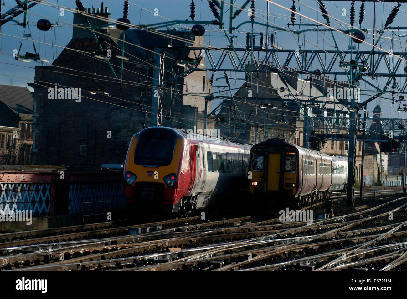 Una Vergine Voyager uscire su un servizio a Plymouth passa un servizio locale da Edinburgh via Shotts su approcci a Glasgow Central. Novembre 20 Foto Stock