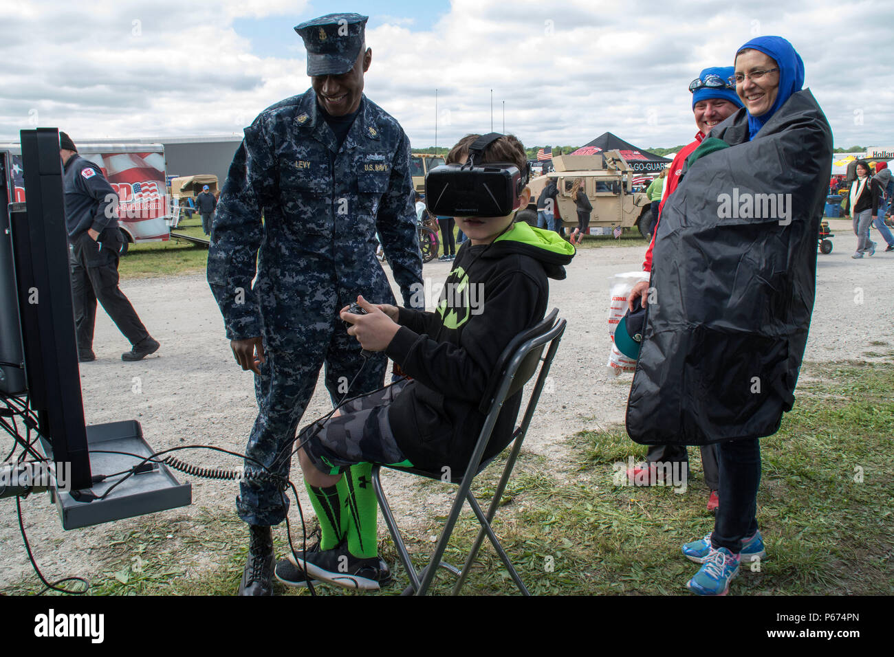 160514-N-II118-003 CHESTERFIELD, Mo. (14 maggio 2016) Chief Operations Specialist Leon Levy, un addetto alla selezione del personale assegnato alla Marina militare del distretto di reclutamento St. Louis, aiuta a un partecipante dello spirito di San Louis Airshow di azionare una coppia di realtà virtuale occhiali presso la Marina di scienza, tecnologia e ingegneria matematica (stelo) tour presentano. L'Airshow, dotate di Blue Angels, tappati Marina la settimana a St. Louis. (U.S. Foto di Marina di Massa lo specialista di comunicazione 1a classe Latrice Jackson/rilasciato) Foto Stock