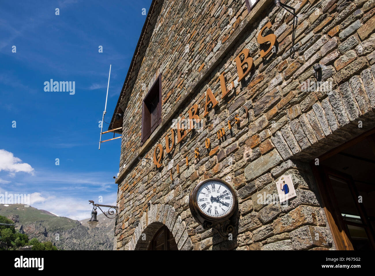 La facciata in pietra e la targhetta a Queralbs stazione ferroviaria sul Cremellera pignone e cremagliera servizio treno attraverso la Vall di Nuria, Catalogna, Spagna Foto Stock