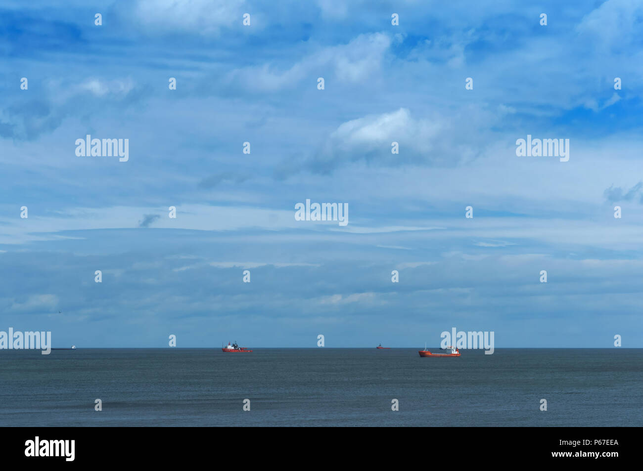 Trivellazioni petrolifere nel mare, le navi in mare all'orizzonte, calma e cielo molto nuvoloso Foto Stock