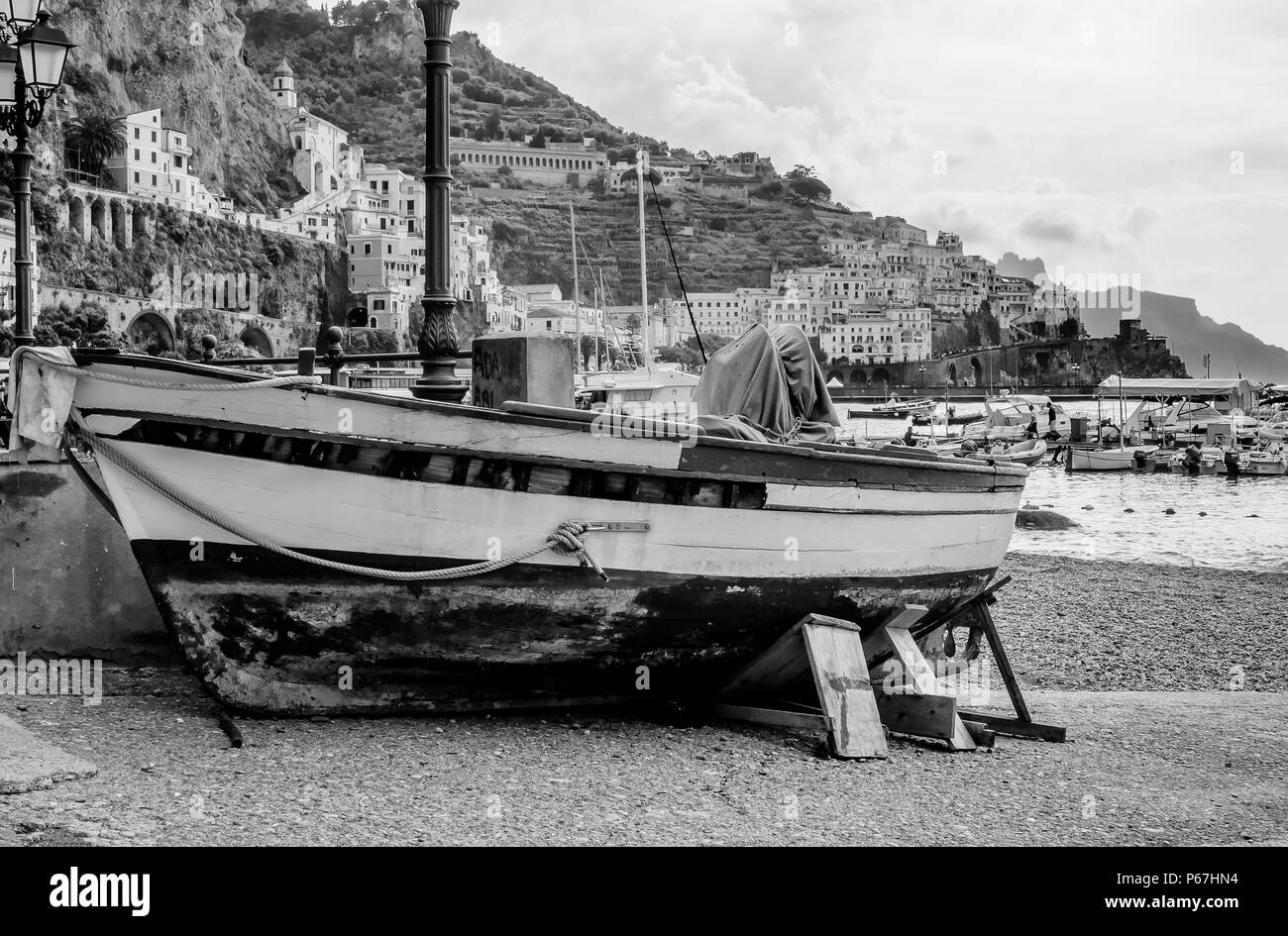 Barca arenarsi con sullo sfondo la città di Amalfi e il suo porto, Campania, Italia Foto Stock