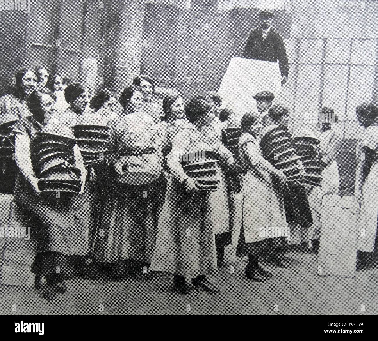 Donne che svolgono il lavoro di guerra. Caricamento di soldati caschi per la consegna per la linea del fronte. In Inghilterra durante la prima guerra mondiale 1916 Foto Stock
