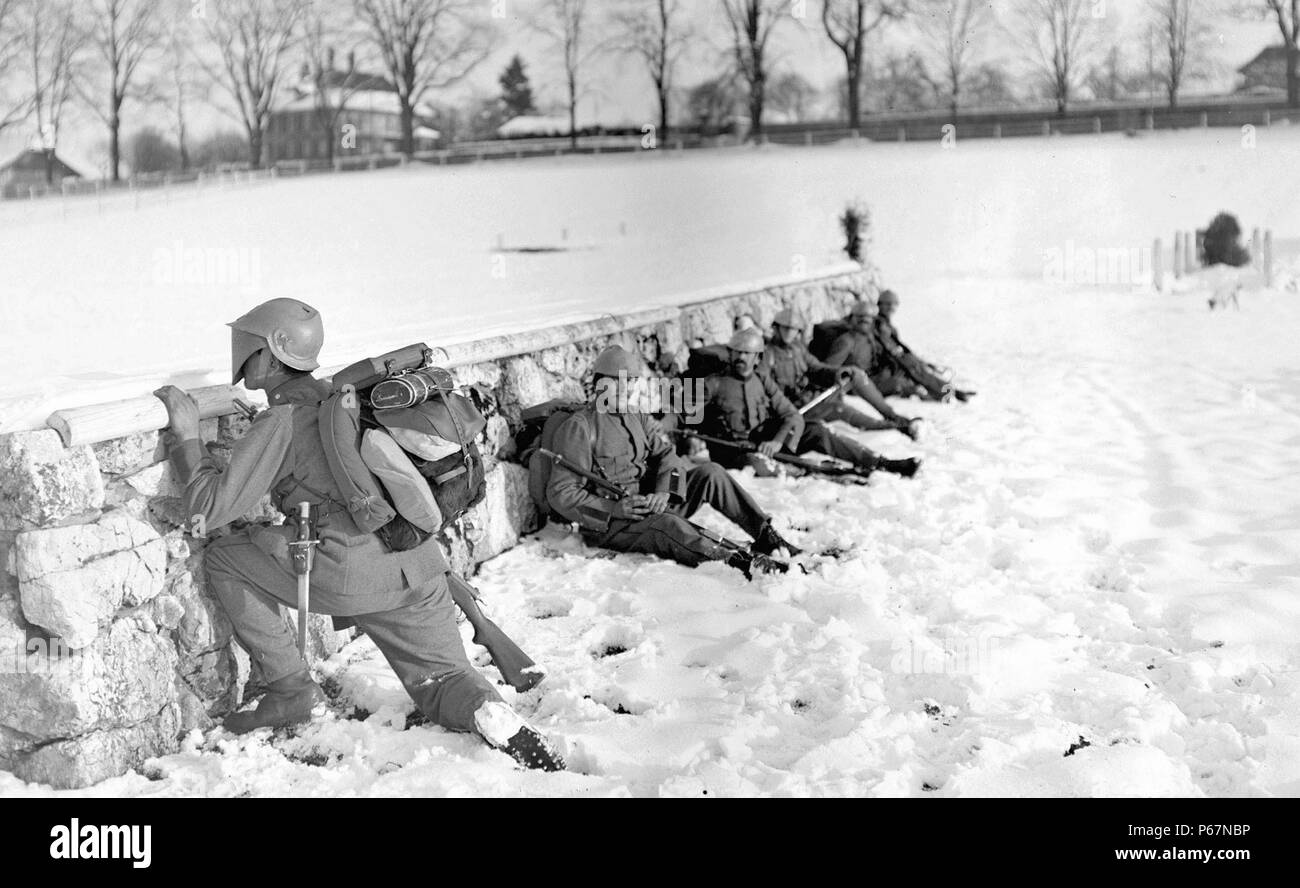 L'immagine mostra un soldato svizzero nella neve peeking su una parete, mentre i suoi compagni soldati prendere la copertura. Datata intorno al 1917. Foto Stock