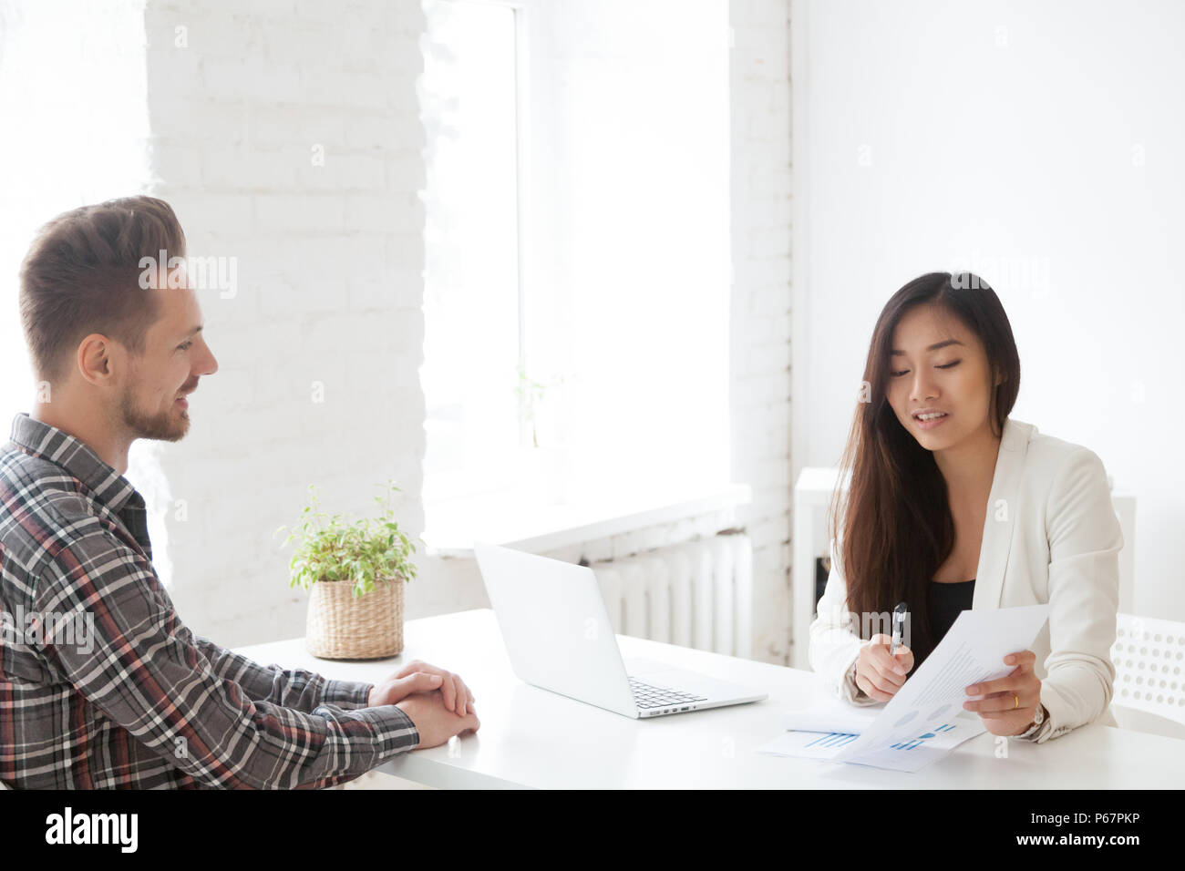 Femmina datore di lavoro asiatici mentoring subordinato maschio sulla finanziaria è Foto Stock