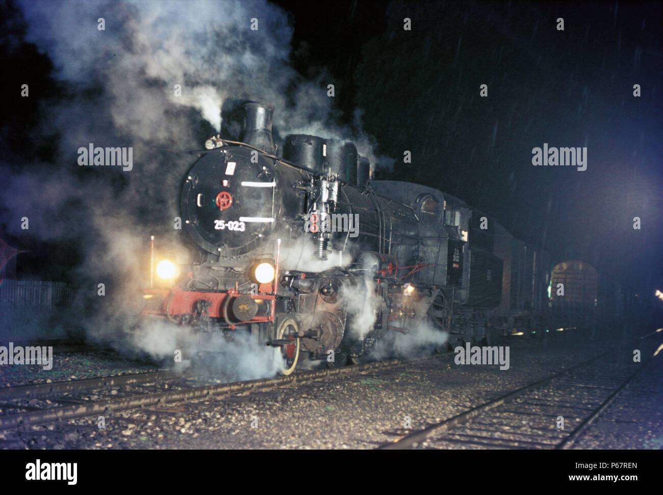 Trasporto merci di notte in Slovenia è presieduta da un ferrovie iugoslave Classe 25 2-8-0 in agosto 1972. Foto Stock