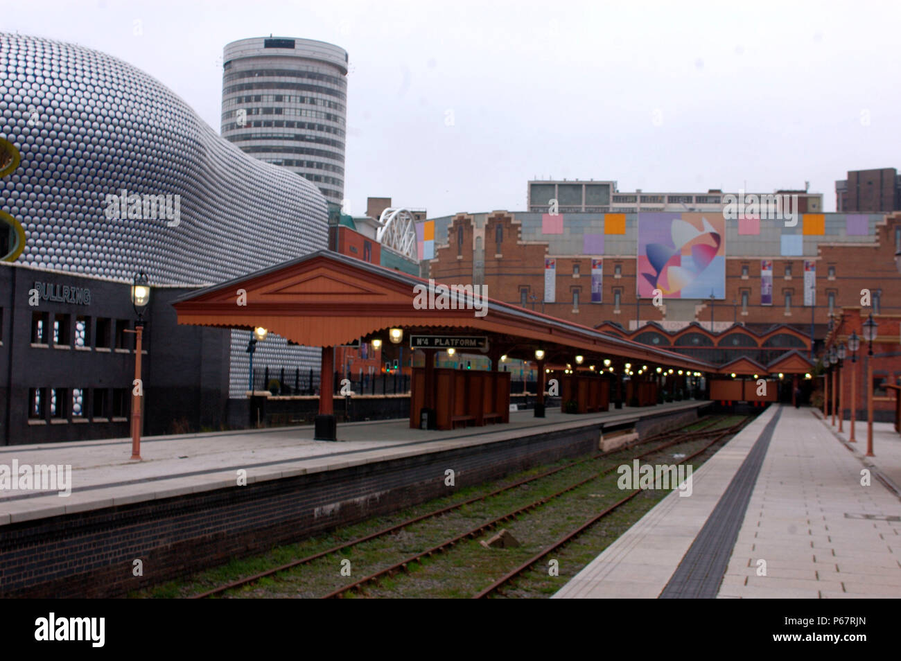 Il vecchio incontra il nuovo in questa vista di Birmingham Moor St stazione dalla estremità del sud della piattaforma 3 guardando a nord verso il famoso Rotunda e l'ultra moderna Bu Foto Stock