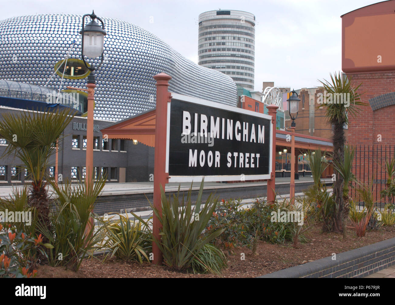 Il vecchio incontra il nuovo in questa vista di Birmingham Moor St station con il patrimonio stazione GWR cartello contrastante con il famoso Rotunda e ultra mod Foto Stock
