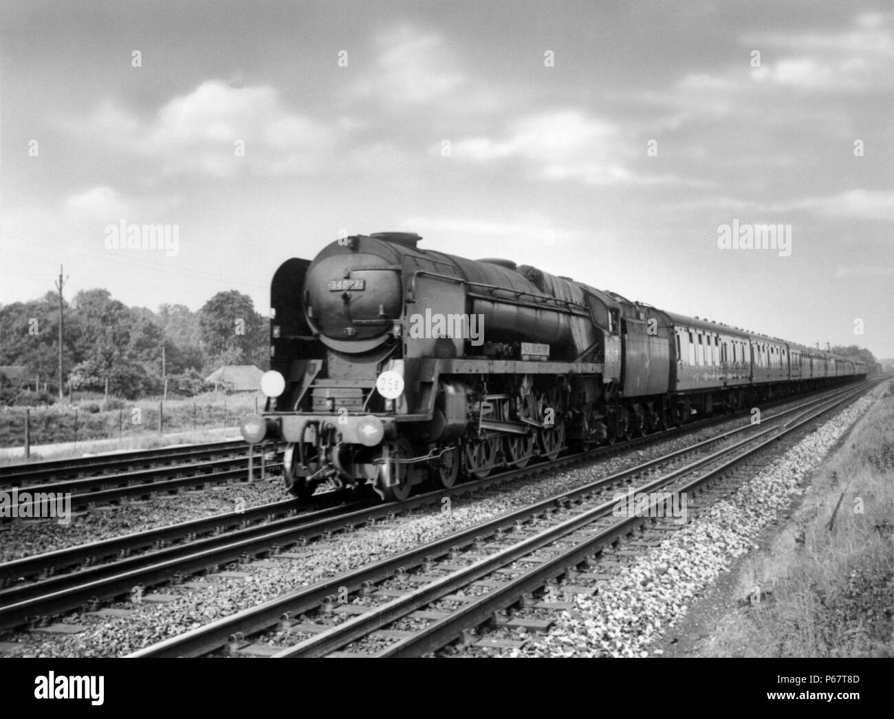 Ricostruita Bulleid Pacific n. 34097 'Holsworthy' passato velocità Worting giunzione con un basso express nel 1964. Foto Stock