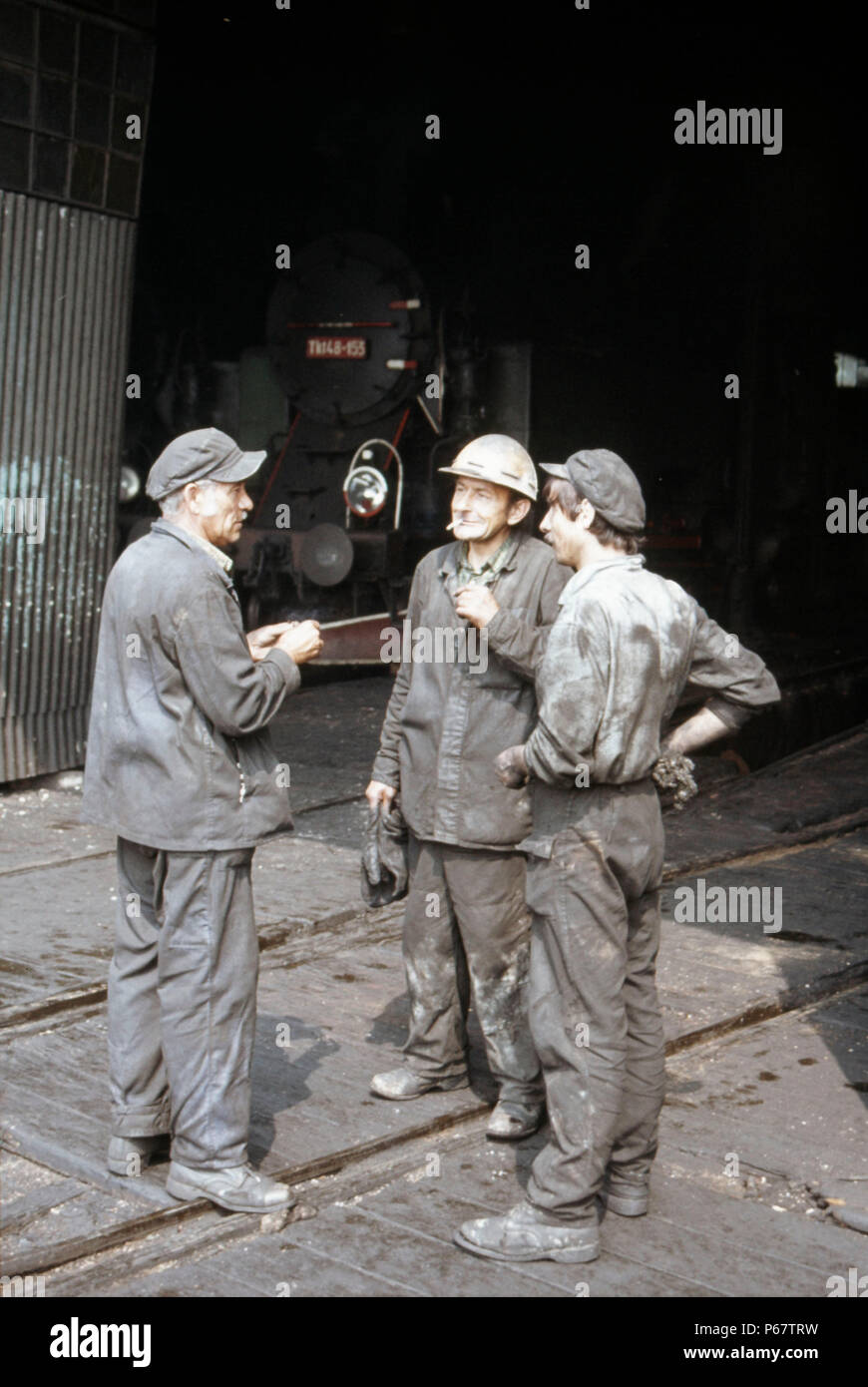 Locomotiva a vapore i montatori impegnati in una conversazione a Klodzko motive power deposito nel luglio 1983. Foto Stock