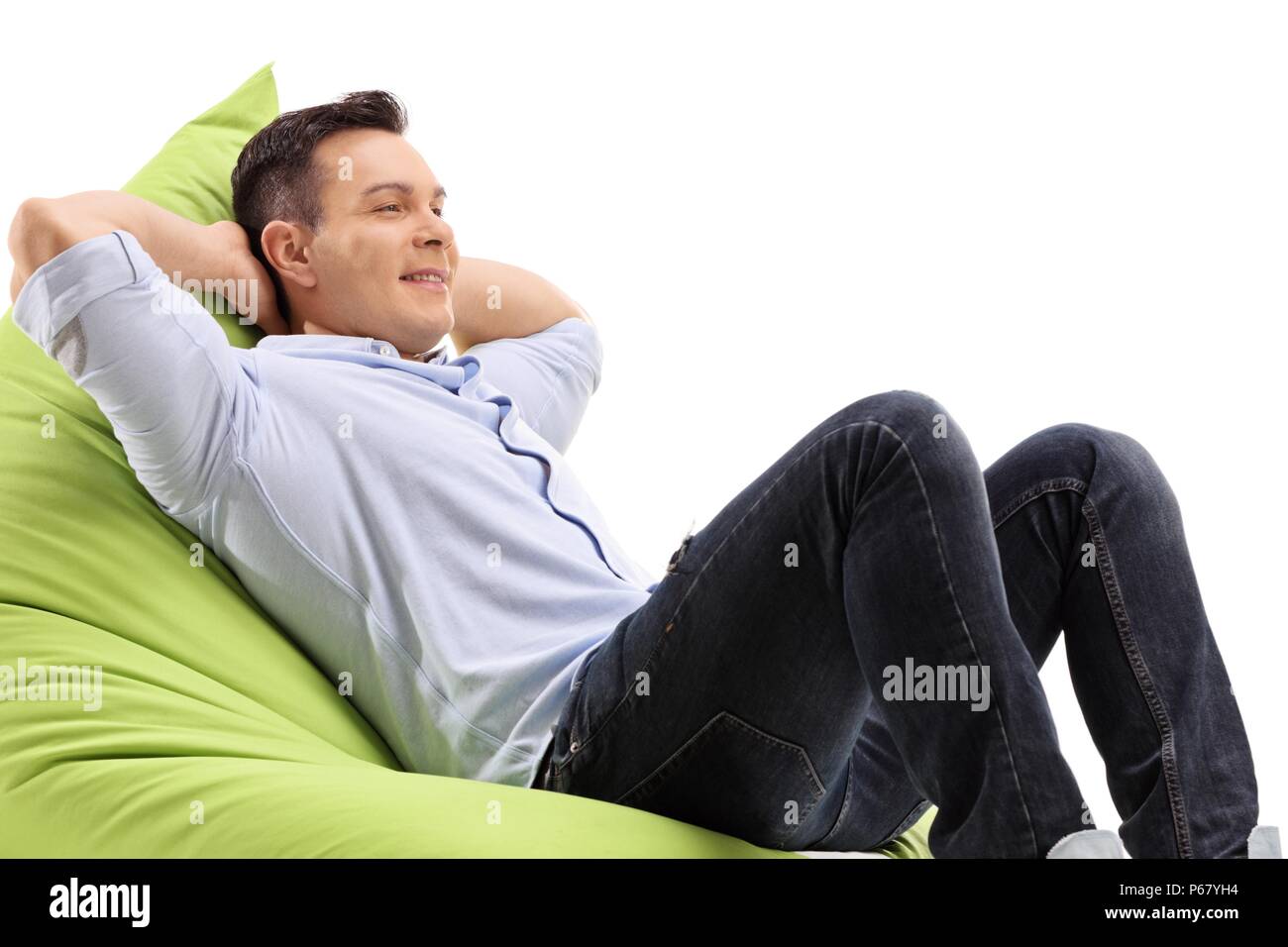 Rilassata giovane uomo seduto su un beanbag isolati su sfondo bianco Foto Stock