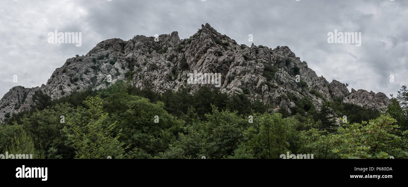 Panorama delle cime rocciose sotto un cielo nuvoloso al Parco Nazionale di Paklenica in Starigrad, Croazia. Foto Stock