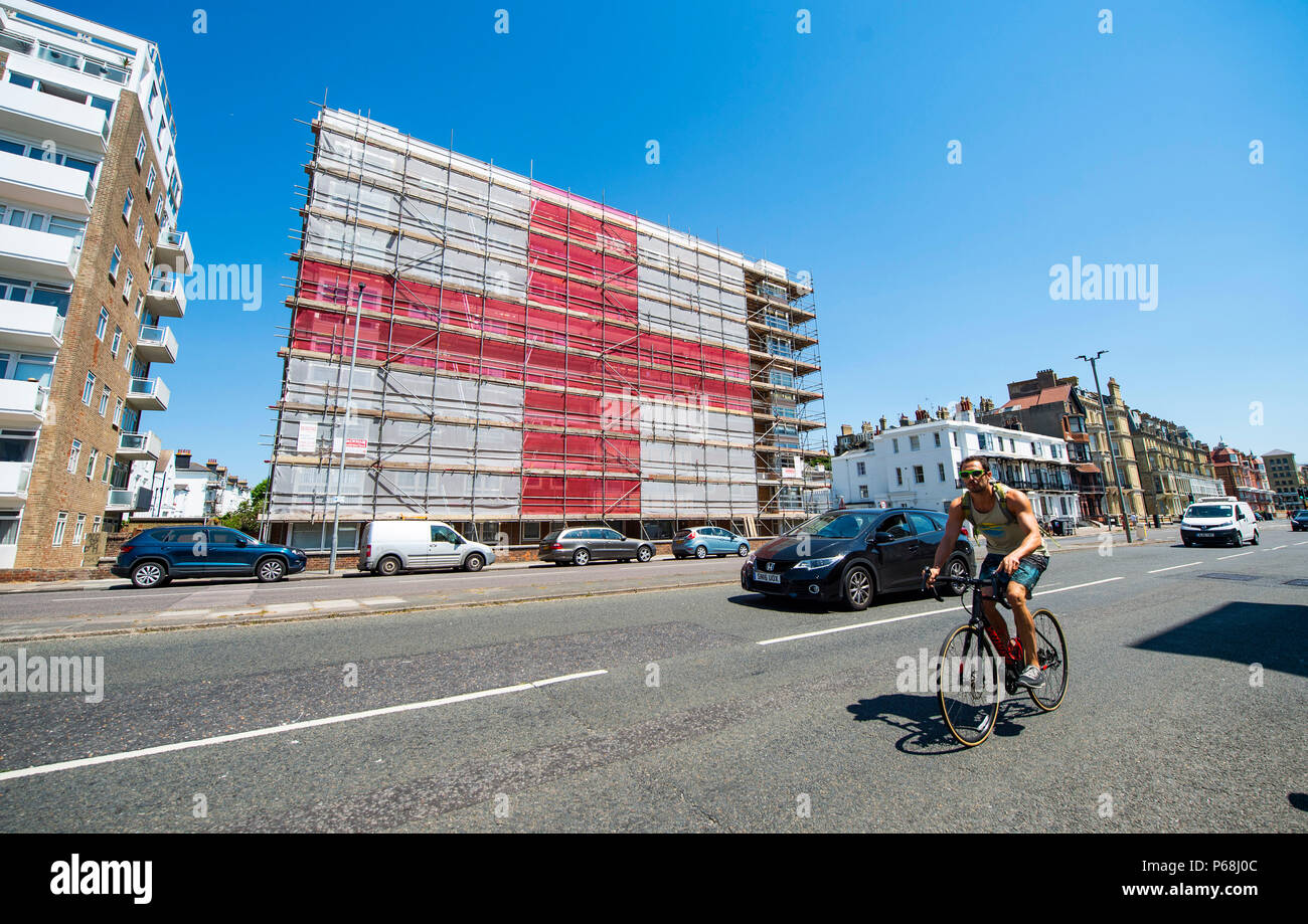 Hove Brighton, Regno Unito. Il 29 giugno, 2018. Un gigante Inghilterra St Georges Cross bandiera è stata messa in piedi da scaffolders su un blocco di appartamenti in St Catherines terrazza lungo il lungomare Hove vicino a Brighton . La 120ft da 60ft bandiera è stata messa in piedi da stagioni Ponteggio a sostegno dell'Inghilterra nel 2018 World Cup che si terrà in Russia con il loro prossimo round gioco arrivando fino contro la Colombia all'inizio della prossima settimana Credito: Simon Dack/Alamy Live News Foto Stock