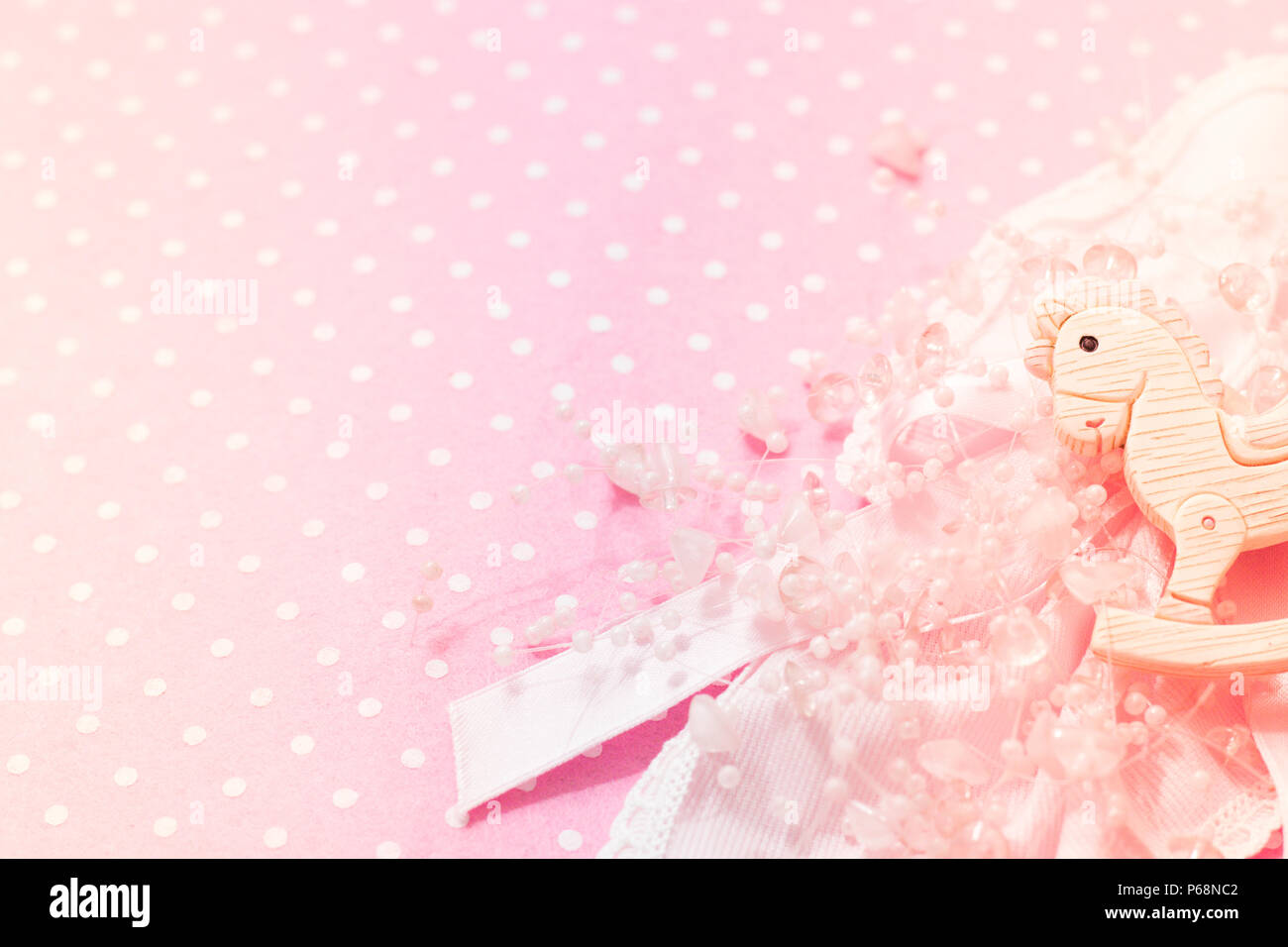 Girl Pink background feltro baby shower party con poco a dondolo giocattolo pony, pizzo e perle decor. Copia dello spazio. Vista dall'alto. Foto Stock