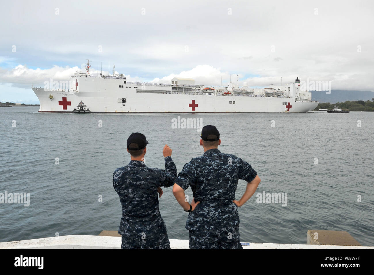 I marinai della U.S. Pacific Fleet Band osservano la nave ospedale USNS Mercy (T-AH 19) mentre si prepara all'ormeggio alla Joint base Pearl Harbor-Hickam il 18 maggio 2016. Mercy sostiene Pacific Partnership 2016, una missione annuale multilaterale di assistenza umanitaria e soccorso in caso di catastrofi nella regione Indo-Pacifico, volta a migliorare la preparazione alla risposta alle catastrofi, la cooperazione regionale e le capacità di supporto medico. Foto Stock