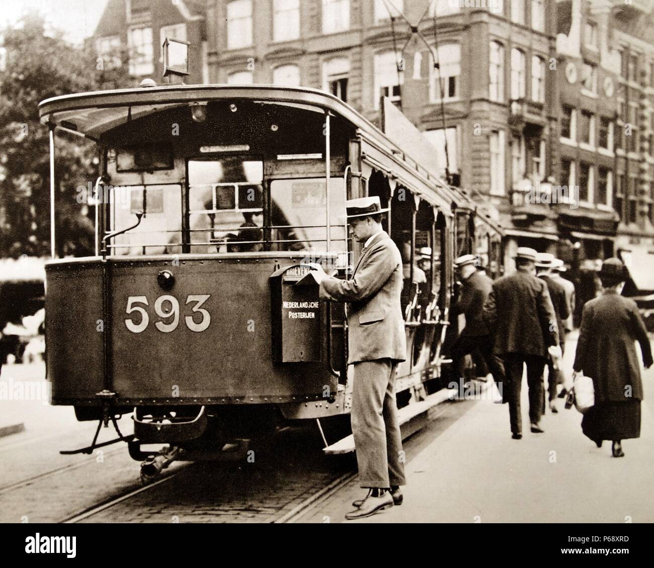 L'uomo spedire una lettera in un post cassetta di raccolta fissato ad un tram in Amsterdam Paesi Bassi 1925 Foto Stock