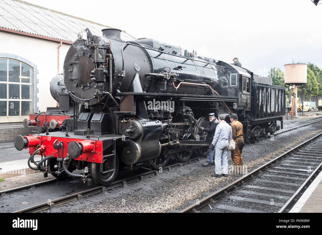 Driver motore briefing la squadra di manutenzione su un ingranaggio di funzionamento problema ha osservato durante una corsa sul West Somerset Railway a Minehead UK Foto Stock