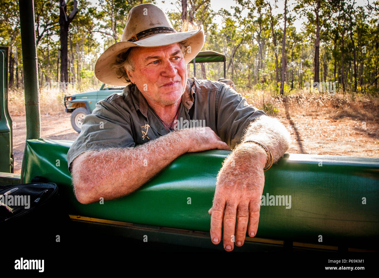 Sab Lord si appoggia nel veicolo safari aperto di Sab Lord Safaris, guardando il bush secco del Territorio del Nord. La guida è nota per la sua profonda conoscenza della boscaglia australiana. Foto Stock