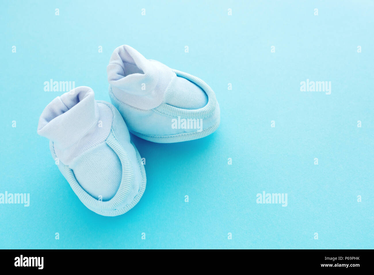 Neonato bambino Scarpe di cotone pastello su sfondo blu Foto stock - Alamy