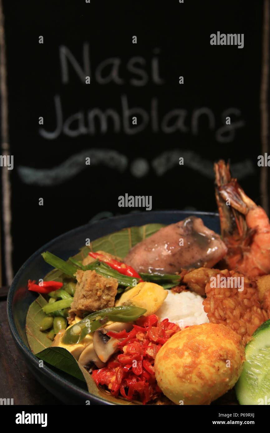 Nasi Jamblang, la firma piatto di riso da Cirebon, West Java. Riso al vapore in foglie di teak parcel servito con abbondanza di piatti laterali. Foto Stock