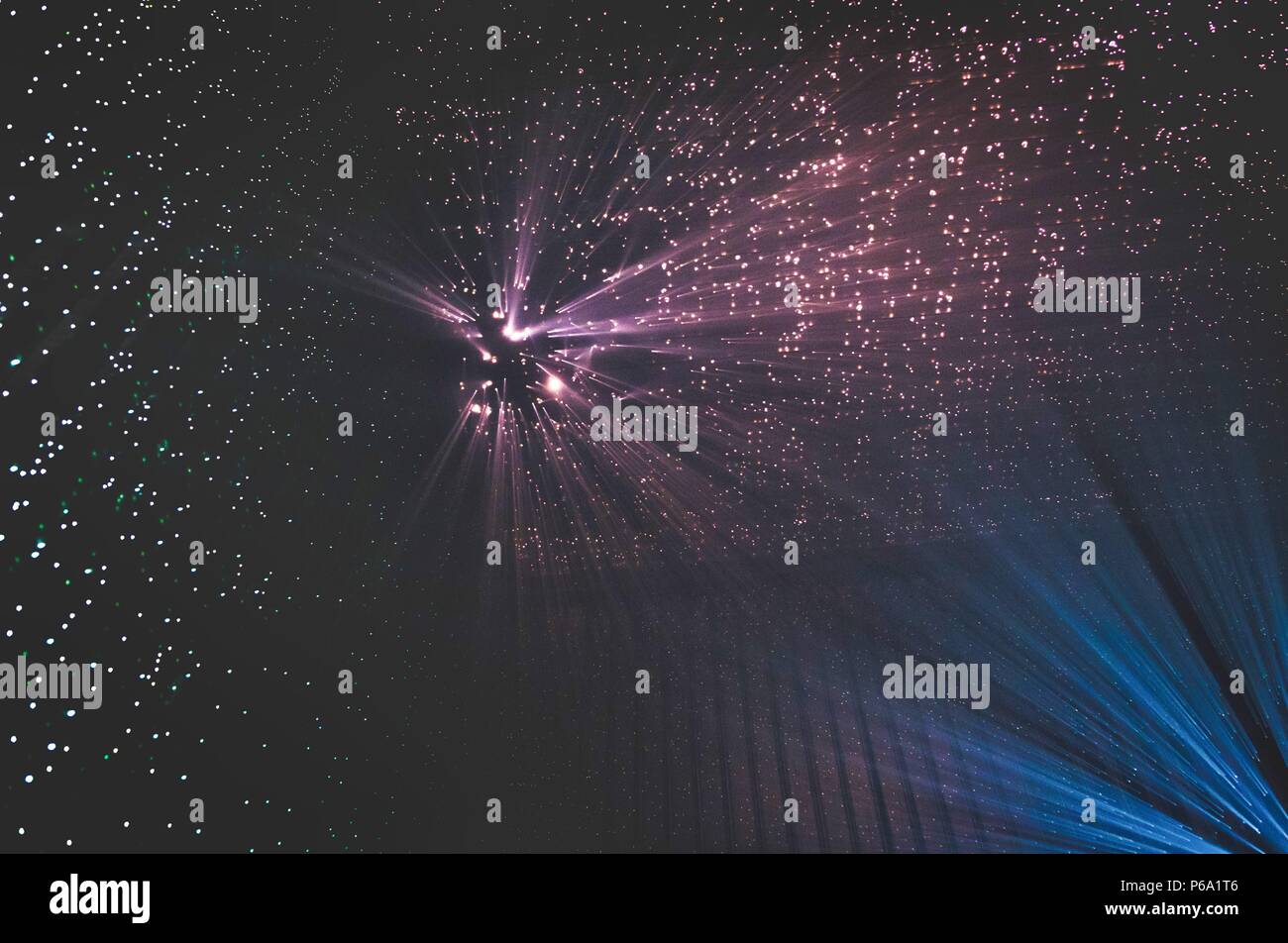 I raggi di luce attraverso piccoli fori in un buio spazio di metallo Foto Stock