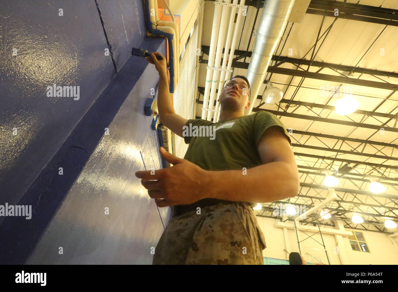 Cpl. Austin Richards, un volo tecnico di apparecchiature con Marine mezzo squadrone Tiltrotor 261, vernici la palestra del Graham Windham Manhattanville della pietra angolare della Comunità nel centro di Manhattan, New York, 27 maggio 2016. I marines stanno visitando la città di interagire con il pubblico e dimostrare le funzionalità e insegnare alla gente di New York circa l'America servizi marittimi. Foto Stock