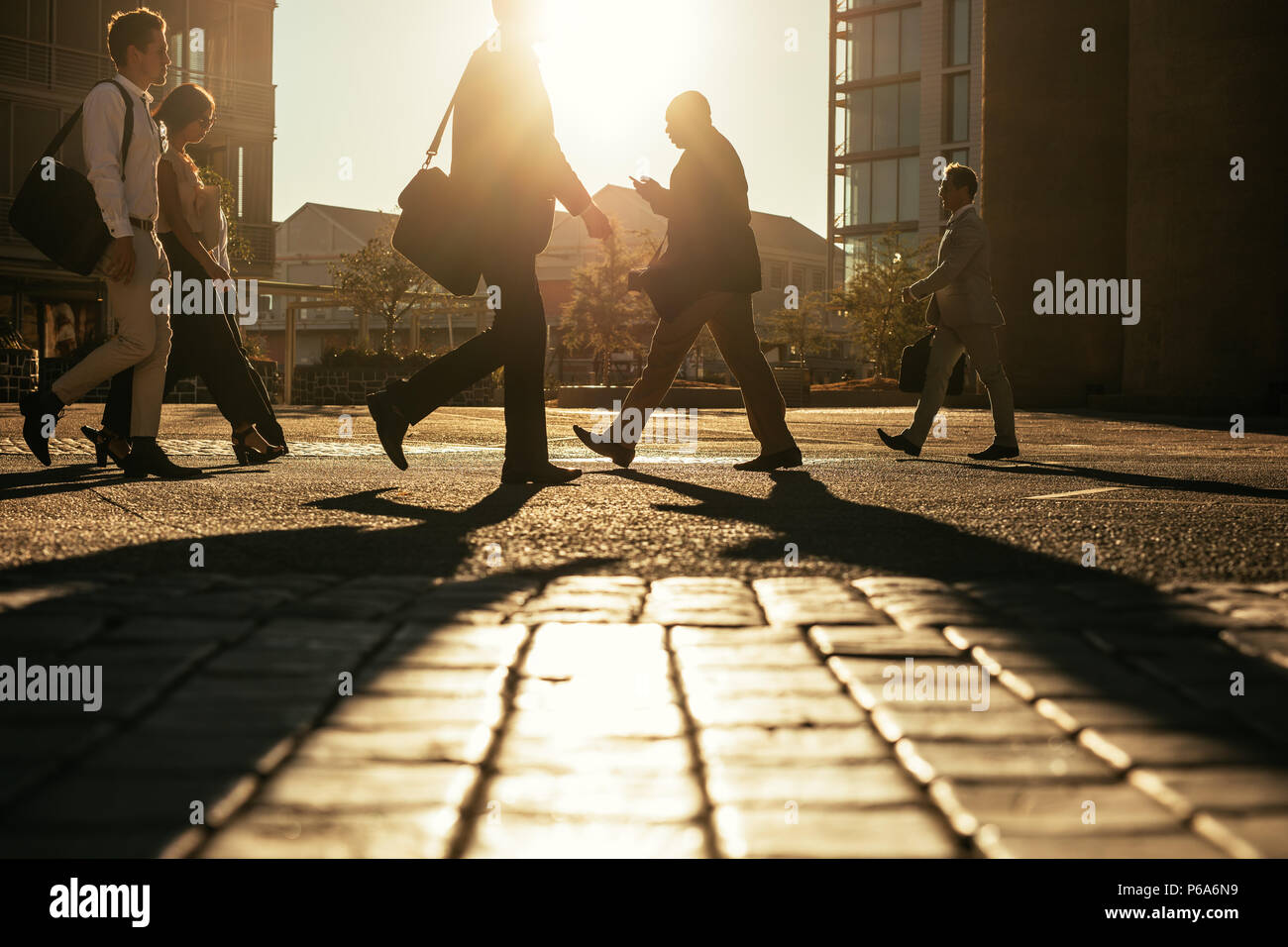 Gli uomini e la donna il pendolarismo per ufficio la mattina ufficio trasporto sacchetti. Gente correre in ufficio al mattino presto e alcuni occupato con il loro cellulare Foto Stock