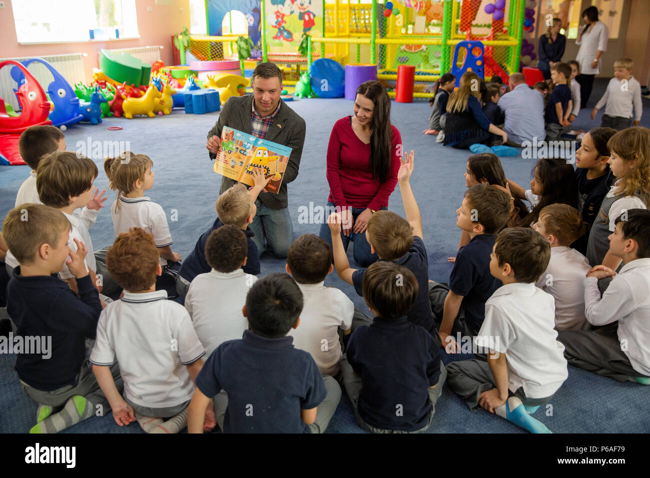 Stati Uniti Marine Corps 1Lt. Concessione T. Peehler, civile operazioni militari planner con il Mar Nero forza rotazionale, e Cristina Diaconeasa, un English-German principali da Ovidius University di Constanta, leggere un libro a kindergarteners da Cambridge Scuola di Constanta, Constanta, Romania, 25 maggio 2016. Marines partecipare nelle relazioni con la comunità eventi al fine di interagire con il pubblico locale al di fuori della formazione militare ambiente. (U.S. Marine Corps foto di Cpl. Kelly L. Street, 2D MARDIV Combattere la telecamera/rilasciato) Foto Stock
