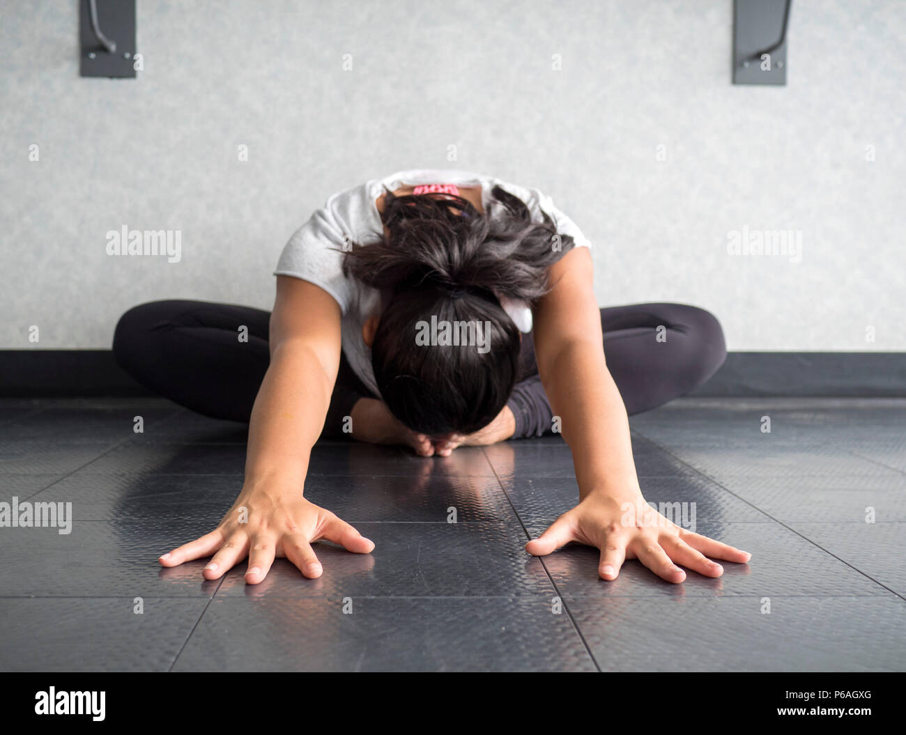 Lo Yoga ballerina Hip tratto in posizione farfalla di raggiungere la testa in avanti a piedi Foto Stock
