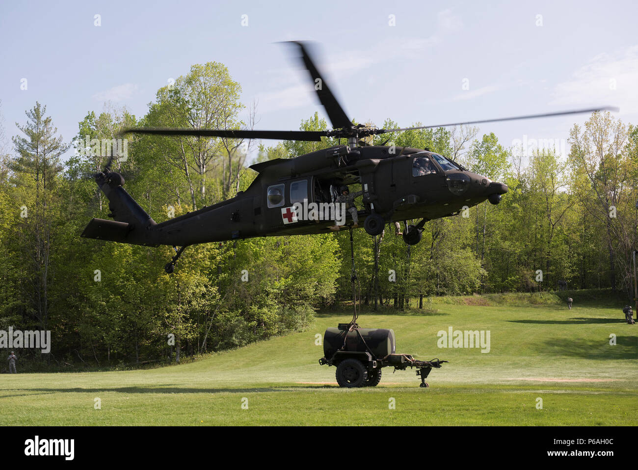 Stati Uniti Soldati di Charlie Company, 3° Battaglione, 126Reggimento di aviazione (Air Ambulance), Vermont Guardia nazionale, utilizzare un UH-60 Blackhawk per sollevare un rimorchio di acqua a Camp Ethan Allen Sito di formazione, Gerico, Vt., 25 maggio 2016. I soldati sono in conduzione sling-esercizi di carico con la Brigata 186th battaglione di supporto al fine di diventare dimestichezza con operazioni come parte della loro formazione annuale. (U.S. Air National Guard foto di Tech. Sgt. Sarah Mattison/rilasciato) Foto Stock