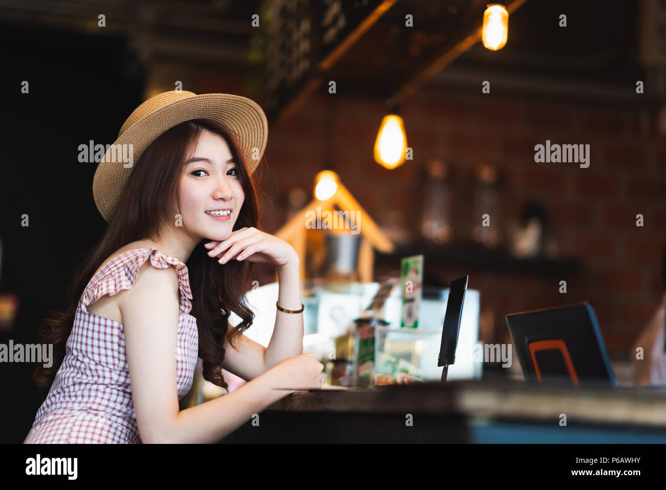 Ritratto di carino e bella asiatica ragazza sorridente in un coffee shop con copia spazio. Cafe cultura uno stile di vita informale, viaggiatore contento concetto donna Foto Stock